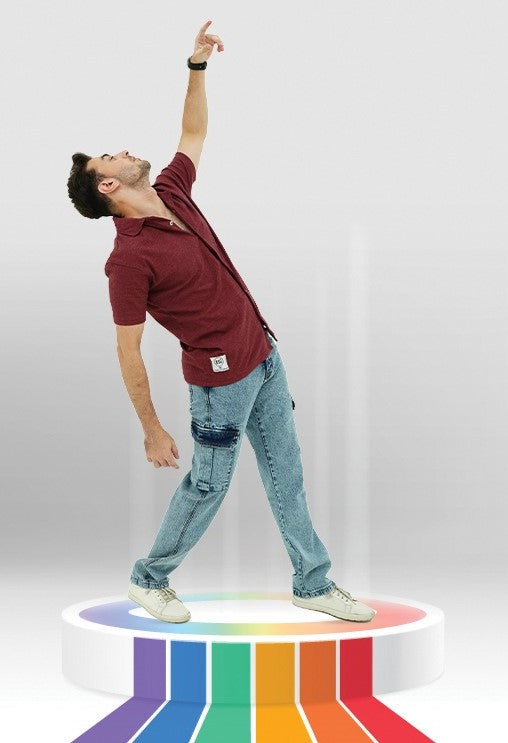 Person standing on a rainbow-colored platform with a plain background
