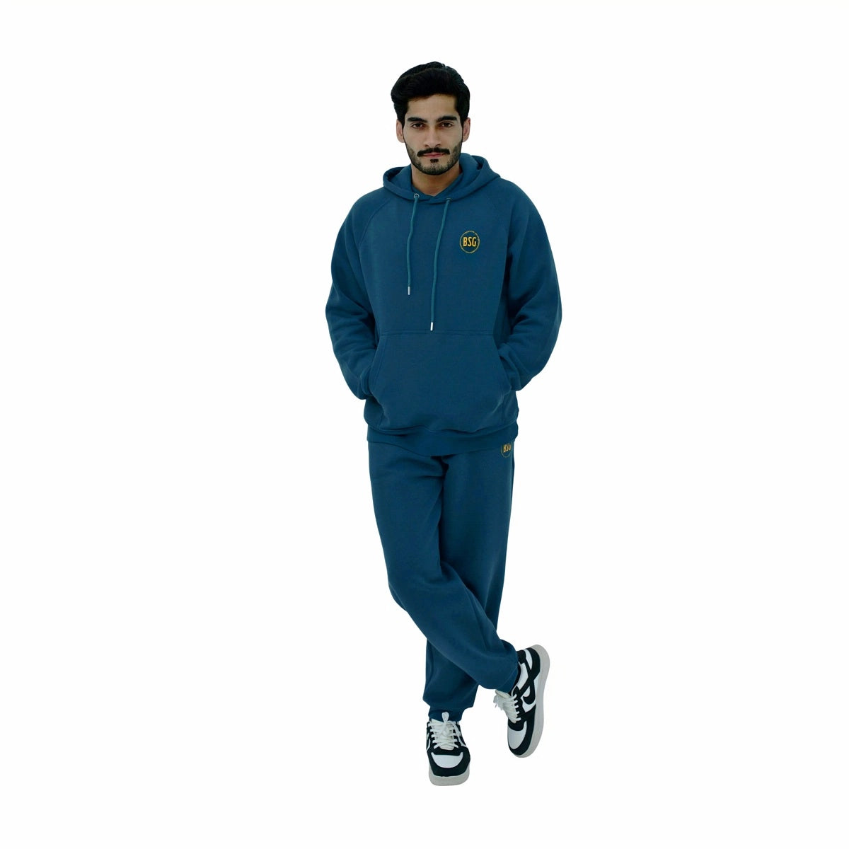 Man wearing a teal tracksuit with a logo on a white background