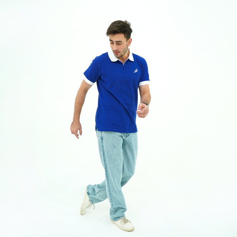Man wearing BSG blue polo shirt with a white collar and light blue jeans on a white background
