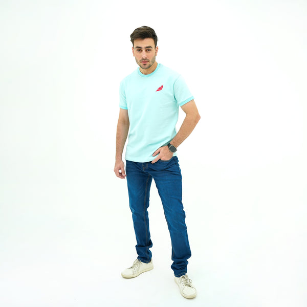 Man wearing BSG light blue t-shirt with a red logo and blue jeans on a white background