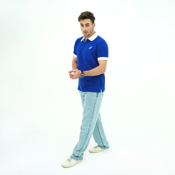 Man wearing BSG blue polo shirt with a white collar and light blue jeans on a white background