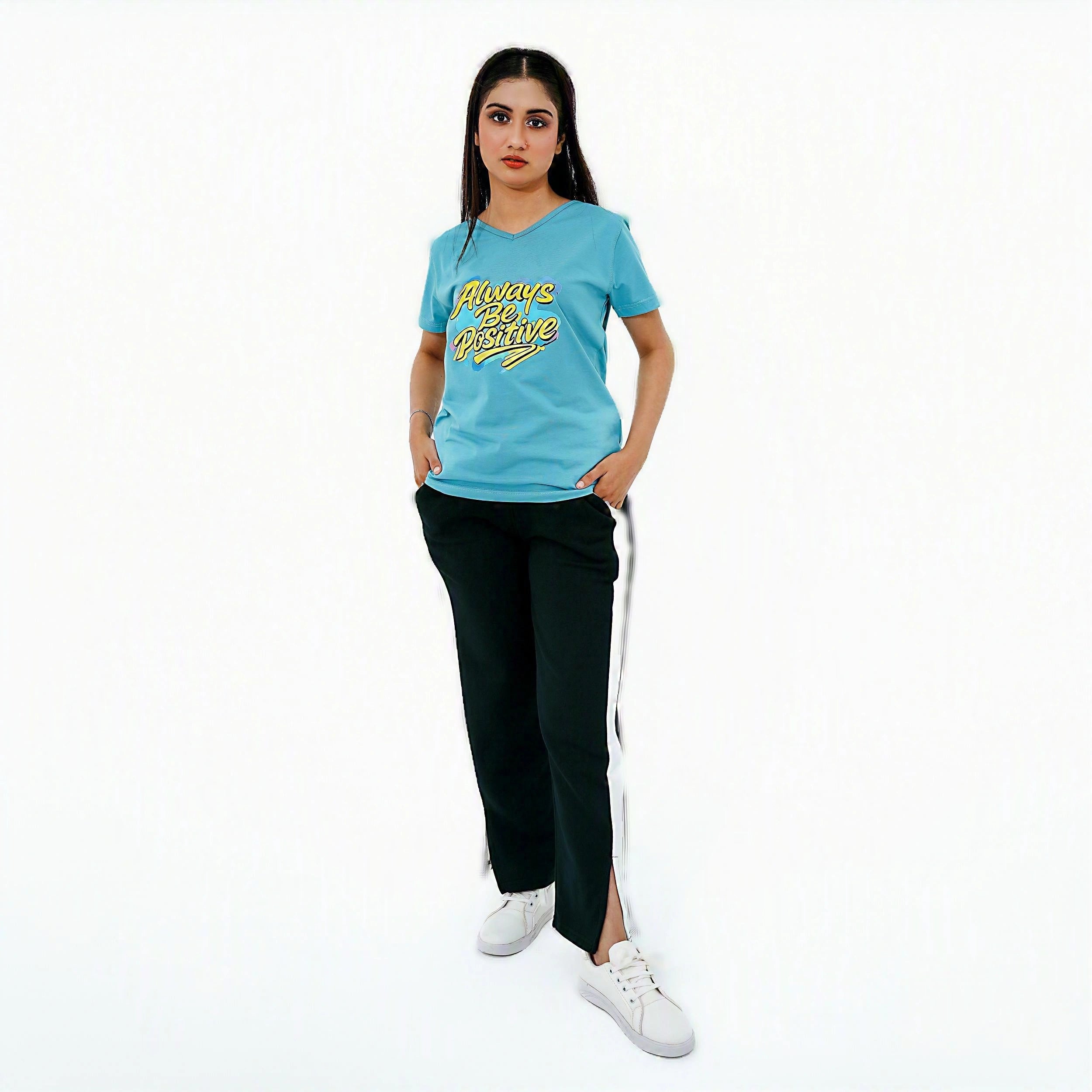 Woman wearing a blue t-shirt with yellow text and black pants on a white background