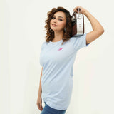 Woman wearing BSG Azure Noir Chic Contrast Tee Shirt in light blue holding a vintage radio on shoulder