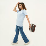 Woman wearing BSG Breezy Blue Flapped Jeans paired with light blue t-shirt and white sneakers