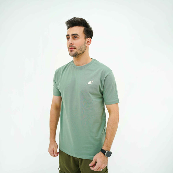 Men's Verdant Charm Pistachio Luxe Tee Shirt by BSG modeled with short sleeves and minimalist chest logo